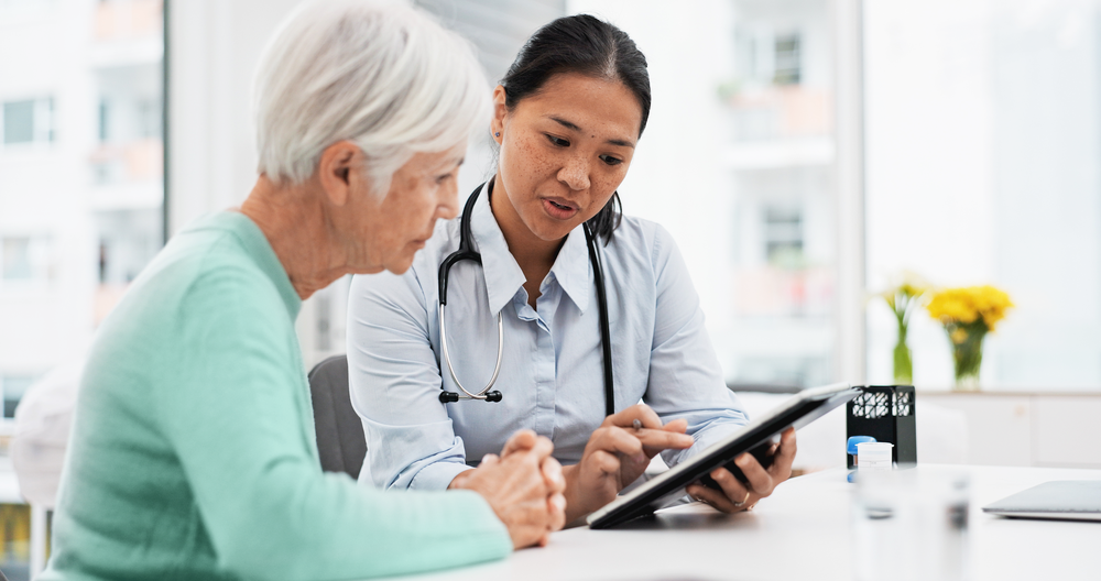 An adult with a clinician reviewing a touch screen