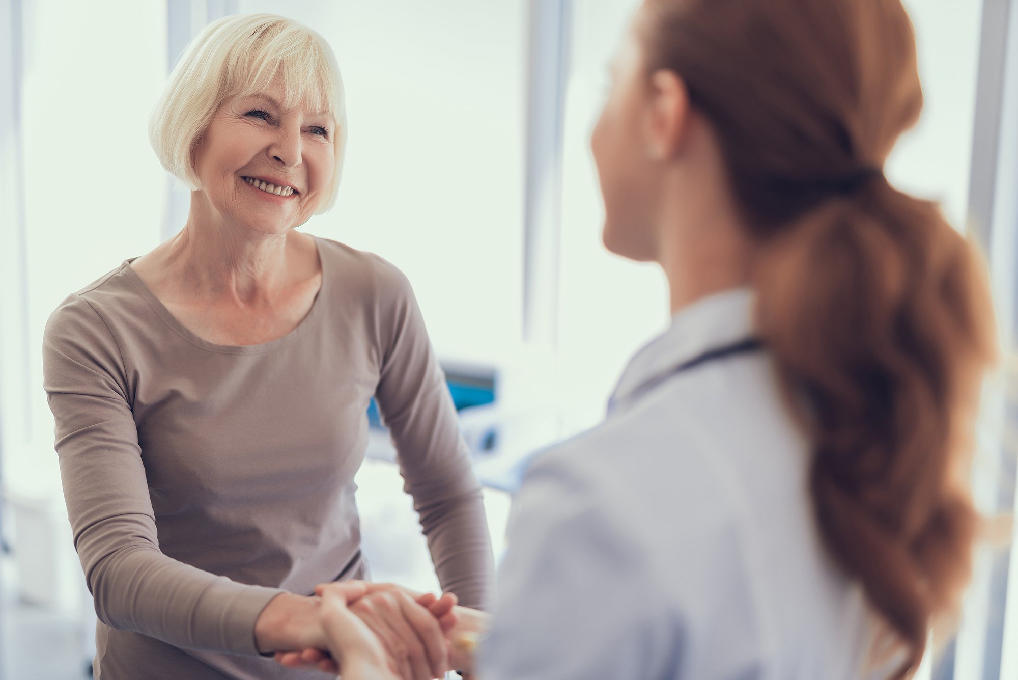 Woman-Smiling-Shaking-Doctors-Hand
