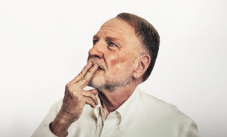 Man in deep thought with fingers over his mouth
