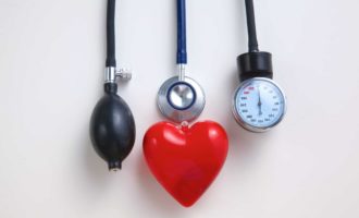 Blood pressure meter and red heart on white background