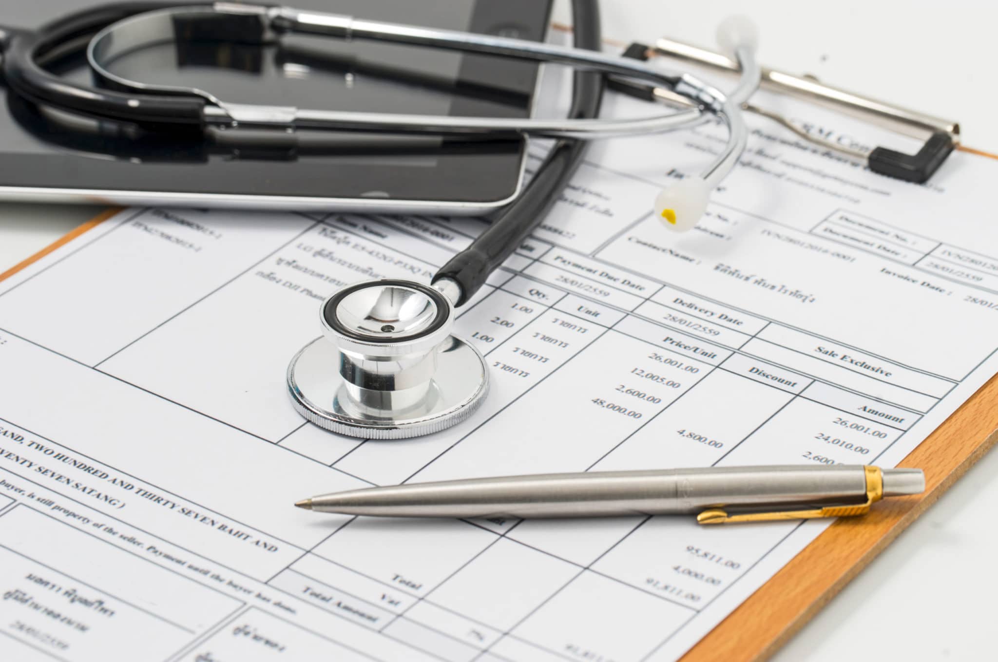 Stethoscope on medical billing statement on table
