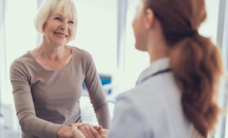 Happy aged woman is thanking doctor for care