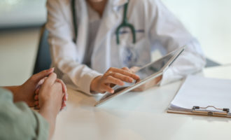 Physician showing a patient a digital cognitive assessment