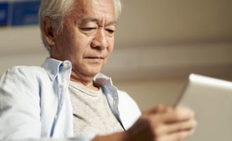 asian old man looking at digital tablet