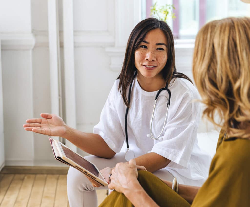 A young doctor with a digital tablet device is explaining the benefits of neurocognitive evaluation to a patient in her clinical practice, emphasizing patient care